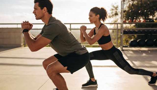 Rooftop partner workout doing squats and lunges during golden hour outdoor fitness session