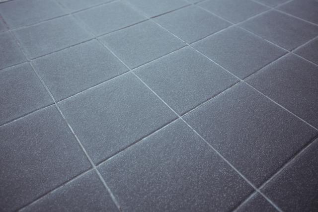 Close-up view of grey paving stone road showing detailed texture and pattern. Useful for backgrounds, architectural designs, construction projects, and urban planning visuals.