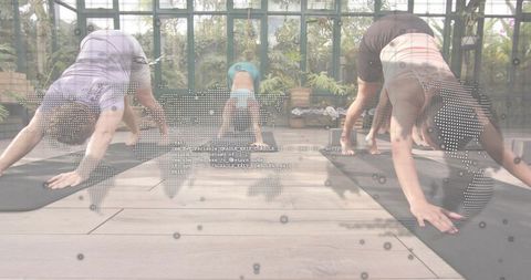 Group Practicing Downward Dog in Glass Greenhouse with Digital World Map Overlay