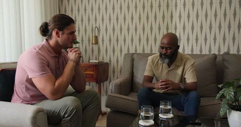 Two Men Engaging in Serious Conversation in Living Room