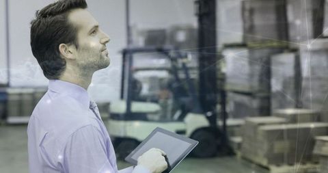 Warehouse manager overseeing inventory with tablet technology