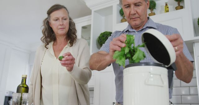 Scene depicts an older couple composting in a modern kitchen, promoting a sustainable lifestyle and eco-friendly practices. Ideal for use in content about environmental responsibility, sustainable home activities, and promoting green lifestyles. Useful for articles, blogs, and educational materials on composting and waste management.