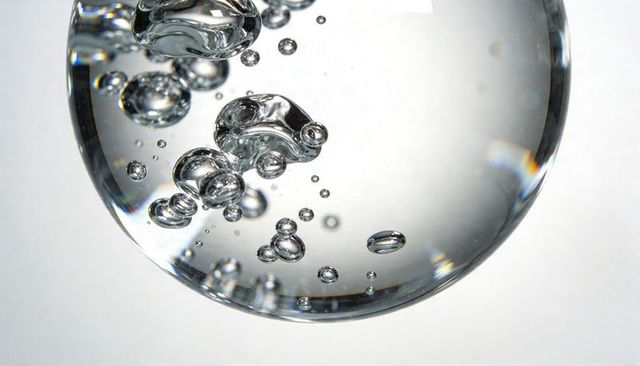 Crystal Orb Capturing Suspended Bubbles with Prismatic Highlights and Glossy Refraction