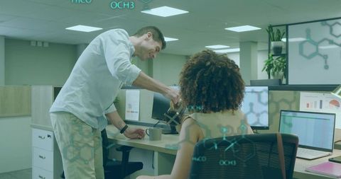 Colleague Pouring Coffee in Lively Open-Plan Office with Dual Monitors