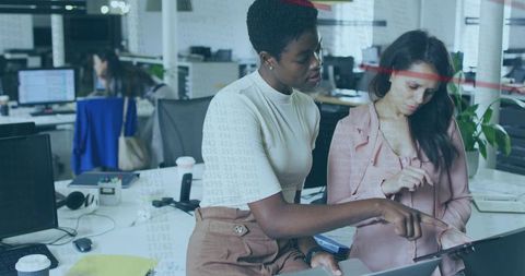 Female Colleagues Collaborating on Tablet in Modern Open-Plan Office Workspace