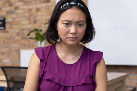 Contemplative Asian Woman in Modern Office with Whiteboard