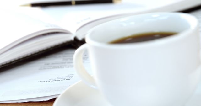 Cup of coffee and notebook with pen background and copy space. Writing, work and office concept.