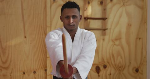 Teen Judoka Practicing with Jo Stick in Gym