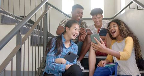 Diverse Teens Laughing on School Stairs Enjoying Break