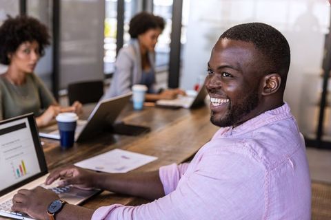 Man in Pink Shirt Engaging in Productive Team Meeting at Workplace