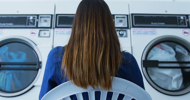 Woman with Long Hair Sitting in Laundromat Observing Machines - Download Free Stock Images Pikwizard.com