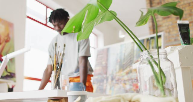 Focused Artist in Bright Studio with House Plant - Download Free Stock Images Pikwizard.com