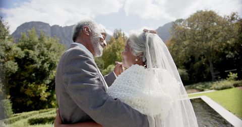 Happy Senior Couple Dancing on Wedding Day in Sunny Garden