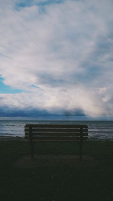 Empty Wooden Bench Overlooking Tranquil Seascape Under Cloudy Sky - Download Free Stock Images Pikwizard.com