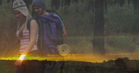 Couple Exploring Woods at Dusk Amid Adventurous Setting
