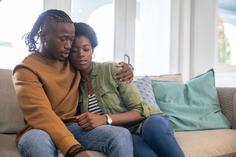 Couple embracing on comfortable sofa in intimate home setting