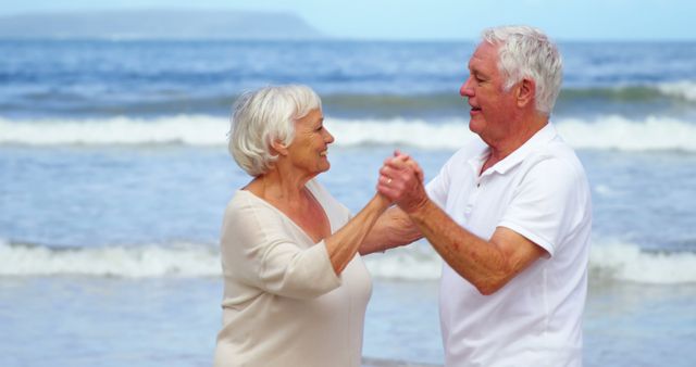 Senior couple dancing on beach during sunny day - Download Free Stock Images Pikwizard.com