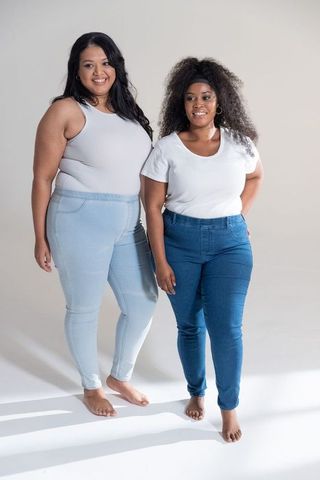 Plus size diverse women smiling barefoot in white tops and blue jeans lifestyle portrait