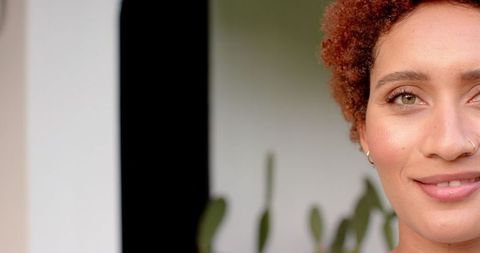 Woman with curly hair highlighting earrings and nose ring