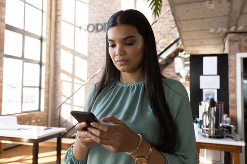 Professional Woman In Urban Coworking Space Using Smartphone
