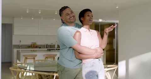 Couple Embracing in Modern Sunlit Kitchen