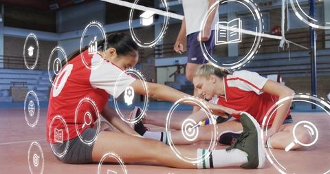 Stretching Volleyball Teammates Wearing Red Jerseys Reaching on Indoor Court with Digital HUD