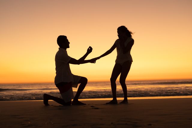 Romantic man proposing woman at seashore on the beach
