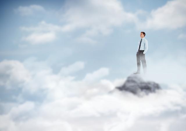 Business man hands in pockets on mountain peak in the clouds - Download Free Stock Photos Pikwizard.com