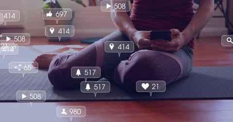 Woman scrolling smartphone on yoga mat with social notifications and engagement overlays