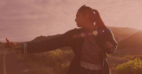 Traveler Hitchhiking at Sunset on Empty Mountain Road