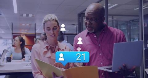 Reviewing documents and collaborating in modern office with social notification showing 21
