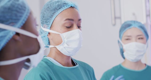 Image of biracial female surgeon talking with diverse colleagues during operation in theatre - Download Free Stock Photos Pikwizard.com