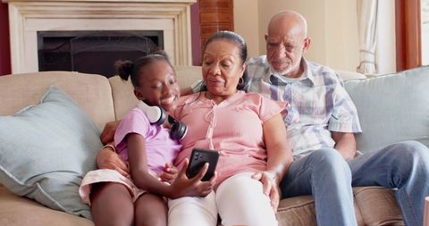 Grandparents and Child Enjoying Smartphone Together at Home