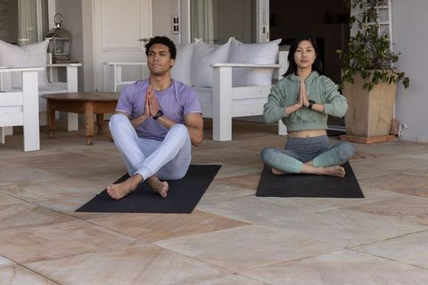 Diverse Couple Practicing Yoga Outdoors in Tranquil Setting