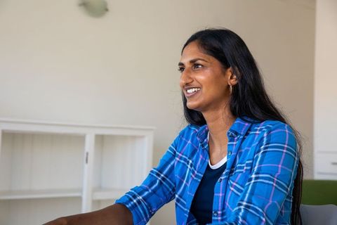 Confident Indian Woman in Blue Plaid Shirt Working in Modern Office