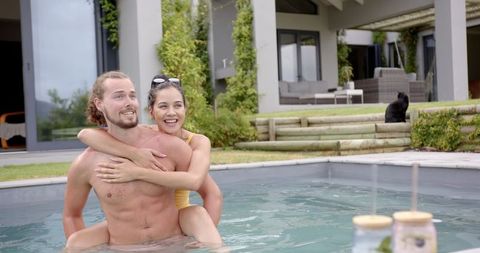 Young couple enjoying relaxing poolside