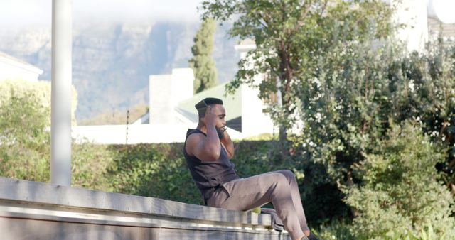 Man Exercising Outdoors Sitting on a Low Wall - Download Free Stock Images Pikwizard.com