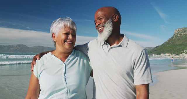 Smiling senior african american couple embracing at the beach. healthy outdoor leisure time by the sea.