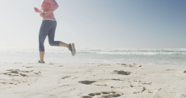 Woman Jogging on Sandy Beach with Ocean in Background - Download Free Stock Images Pikwizard.com