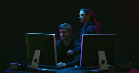 Two Men Collaborating at Computers in Dark Tech Environment - Download Free Stock Images Pikwizard.com