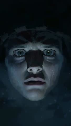 Staring male face submerged in blue light with brow strap, wide-eyed vertical video