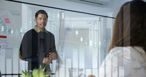 Young professional presenting data on flip chart during team meeting with graph overlays