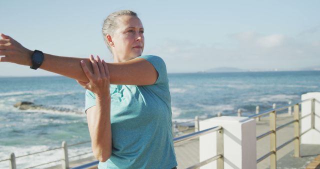 Senior Woman Stretching Outdoors by Ocean on Sunny Day - Download Free Stock Images Pikwizard.com