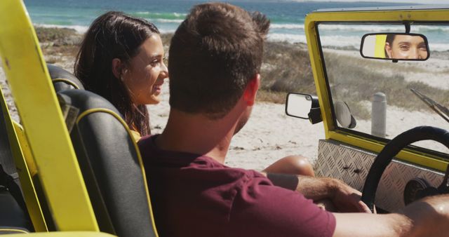 Happy caucasian couple sitting in beach buggy by the sea talking. beach stop off on summer holiday road trip.