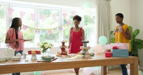 Women Preparing Baby Shower with Cakes and Gifts