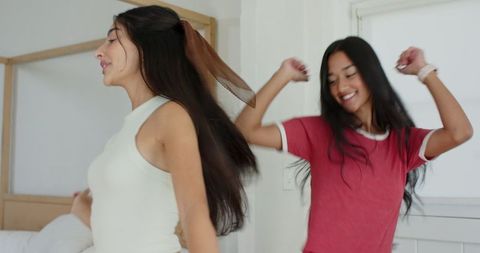 Joyful Friends Dancing Energetically in Bedroom