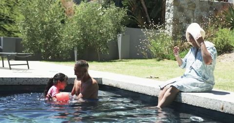 Family Enjoying Relaxed Day by Sunny Poolside