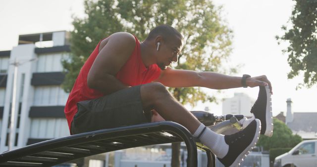 Athlete Stretching on Urban Rooftop in Red Tank Top - Download Free Stock Images Pikwizard.com