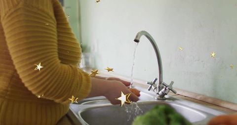 Rinsing vegetables at kitchen sink with golden glow