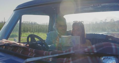 Happy Couple Planning Road Trip Adventure in Sunlit Car Interior